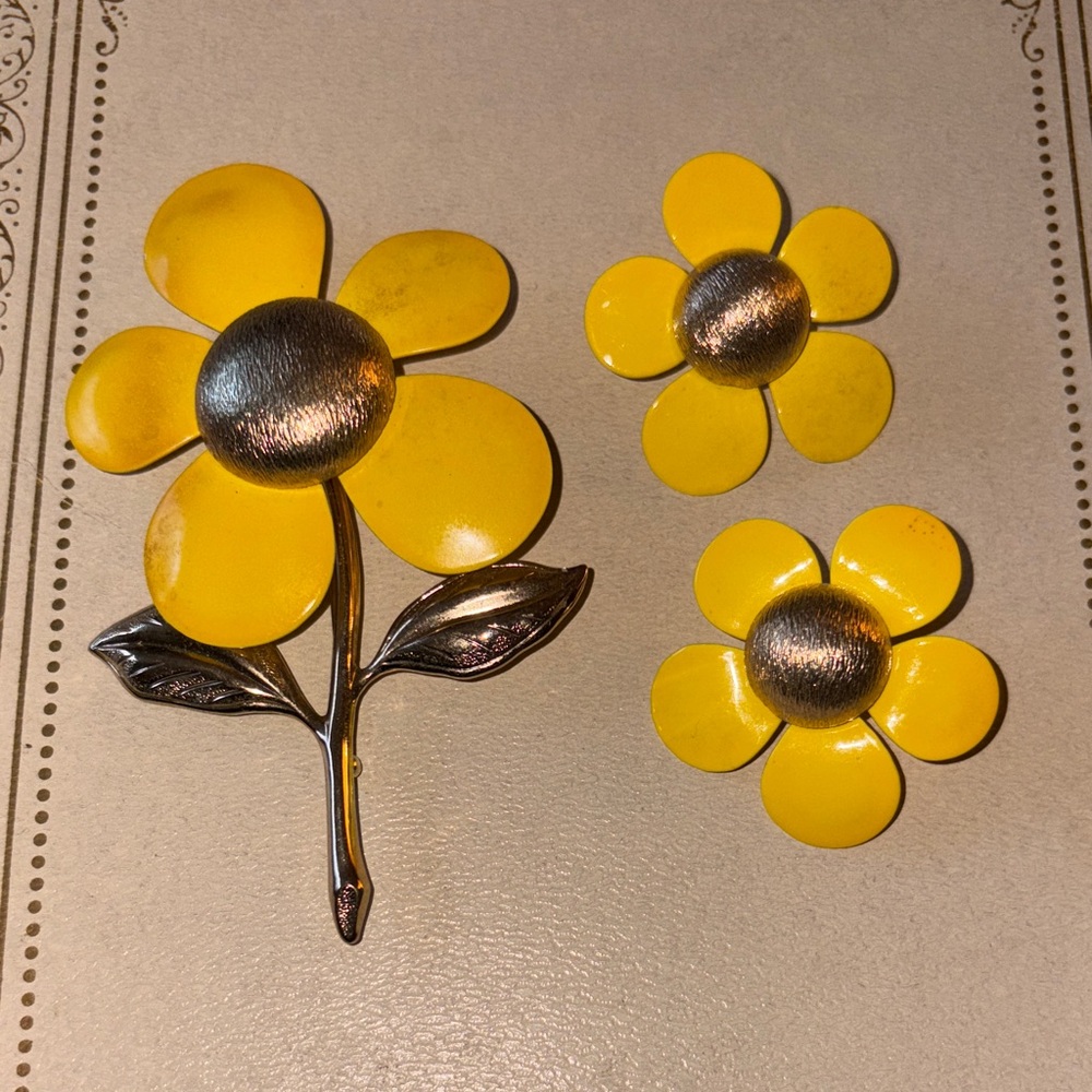 Sarah Coventry 1968 "Flower Flattery" enamel daisy brooch and clip-on earrings.